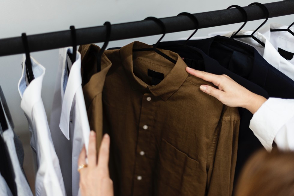 woman rifling through a clothes rack