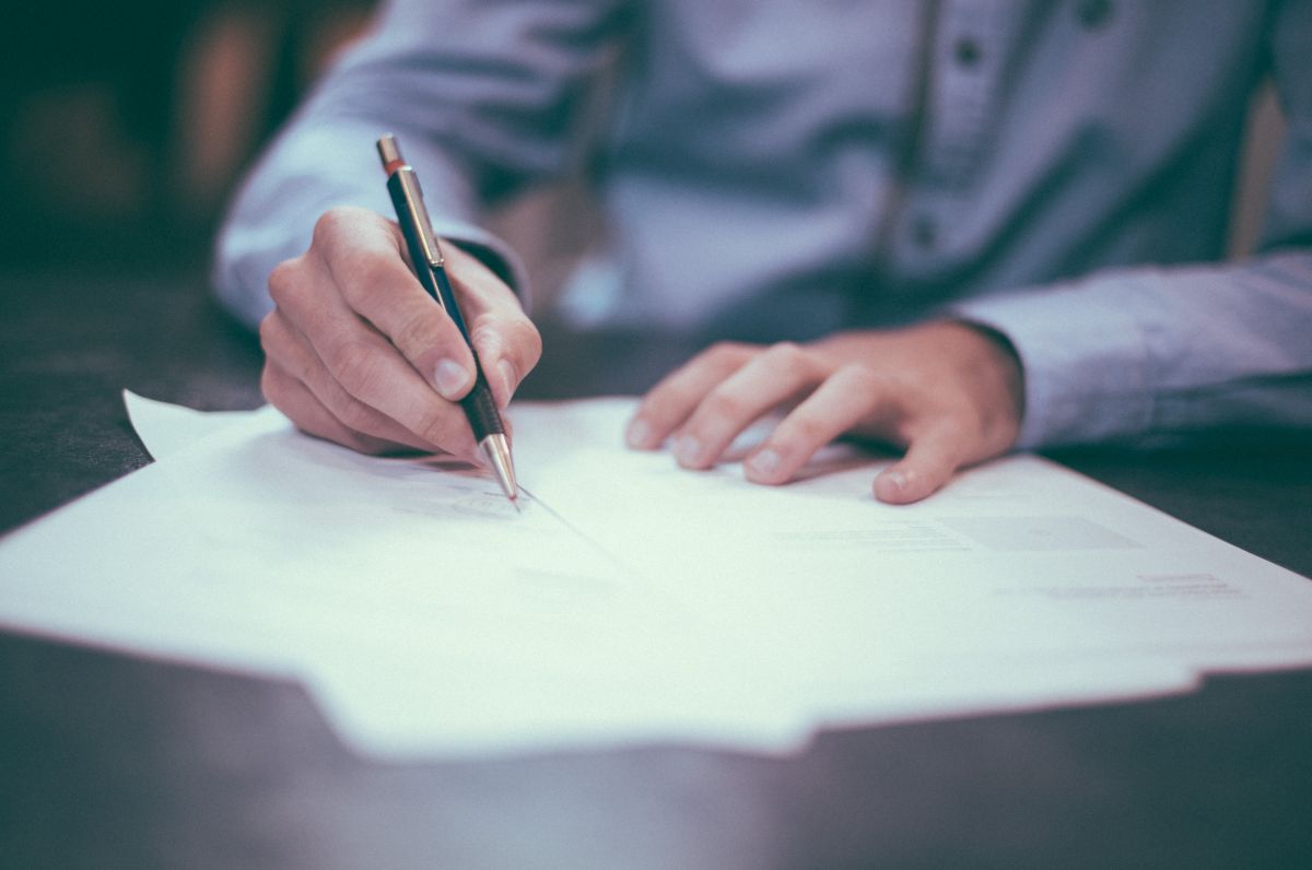 person writing on paperwork