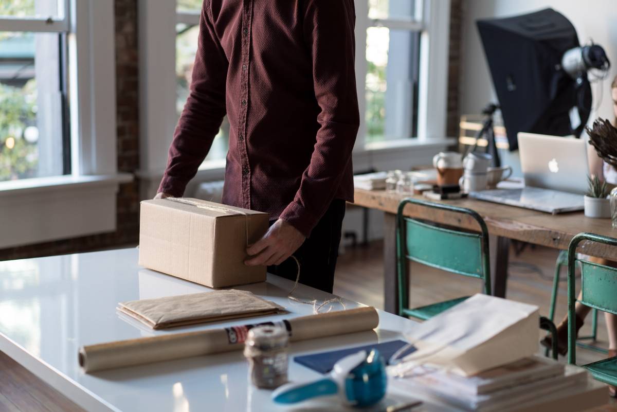 person wrapping a box to be shipped